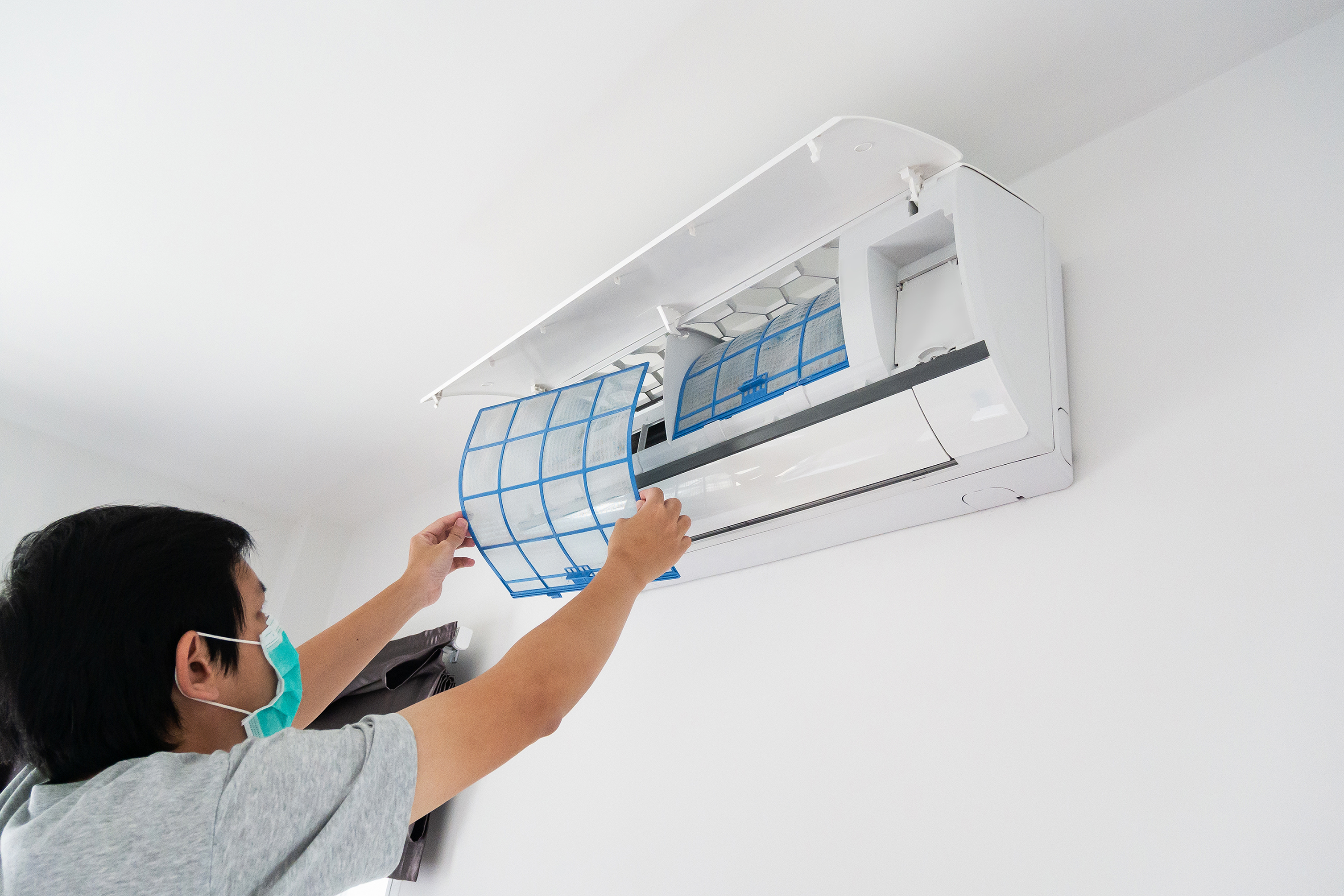 An image of cleaning out a dirty filter and placing new filters inside the air conditioner of a home.