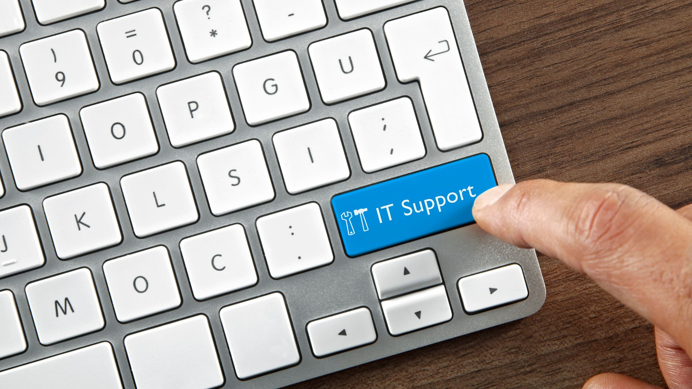 finger clicking button on keyboard that says "IT support" 