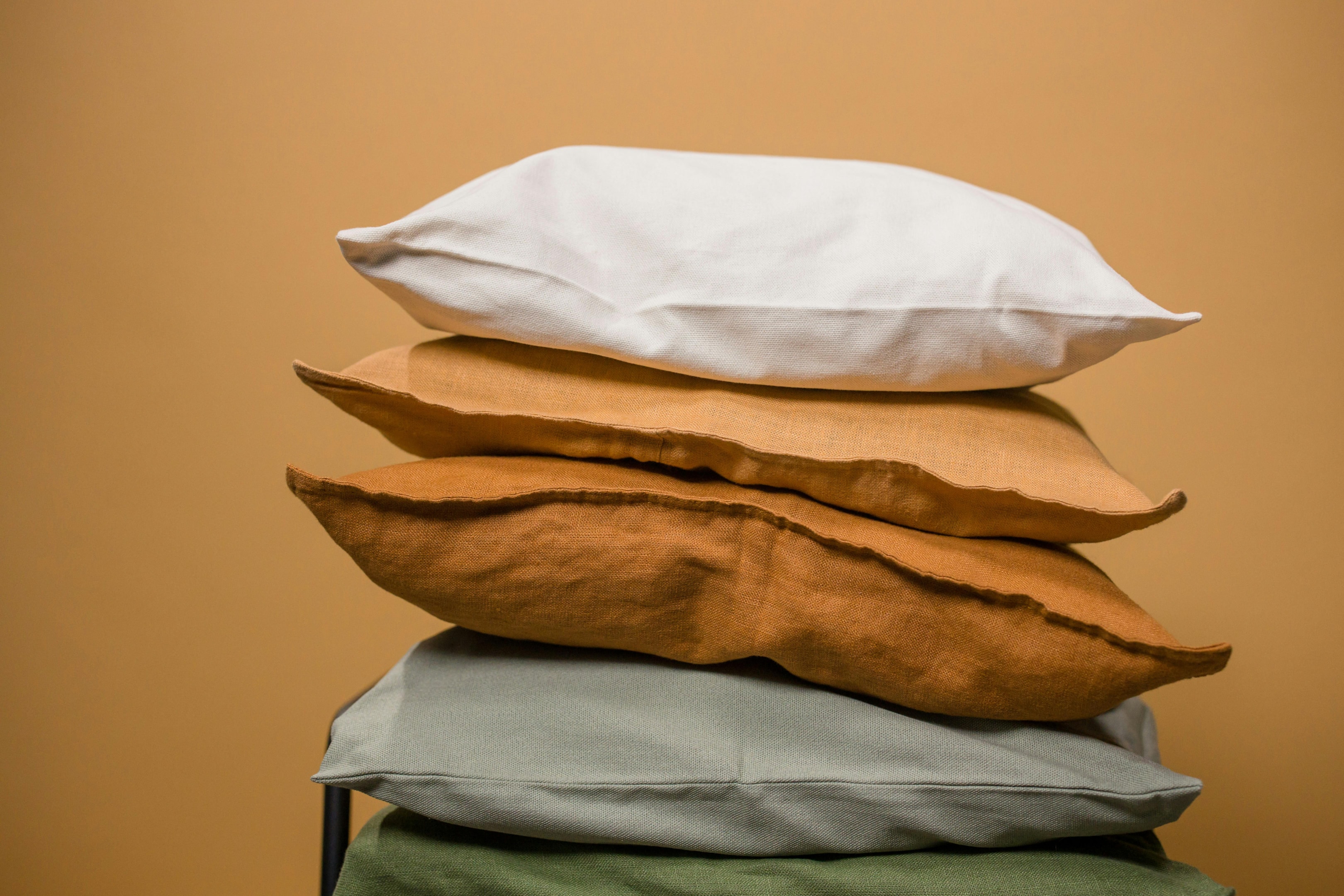 Photo by Ron Lach : https://www.pexels.com/photo/stack-of-colorful-pillows-isolated-on-beige-background-8762876/