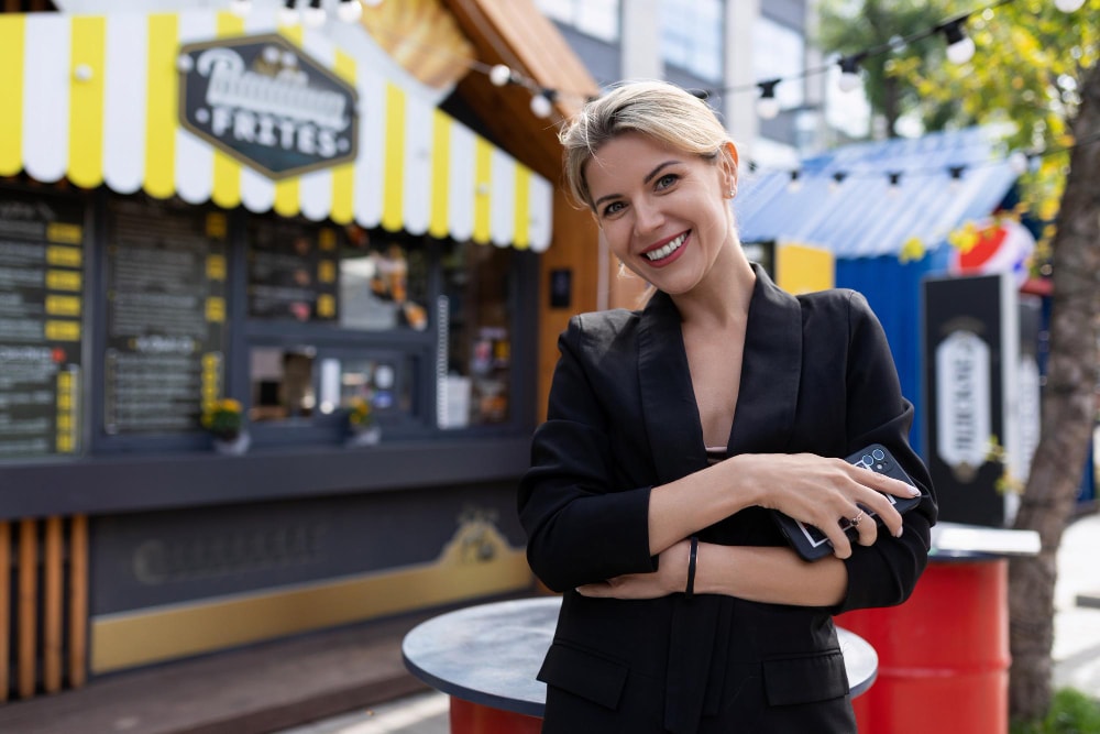 A business woman smiling because her telecom systems and cloud computing help save her business. 