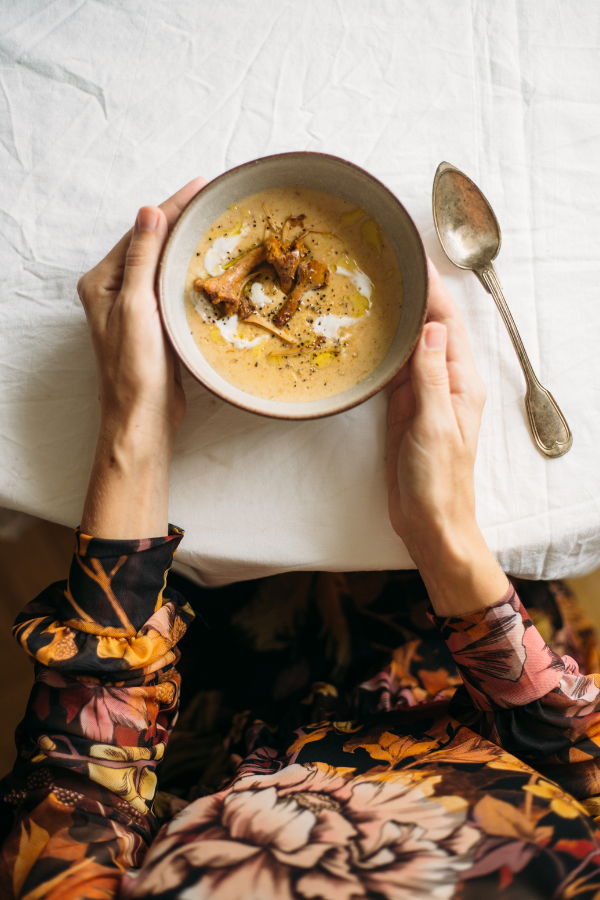 a woman eats a bowl of soup