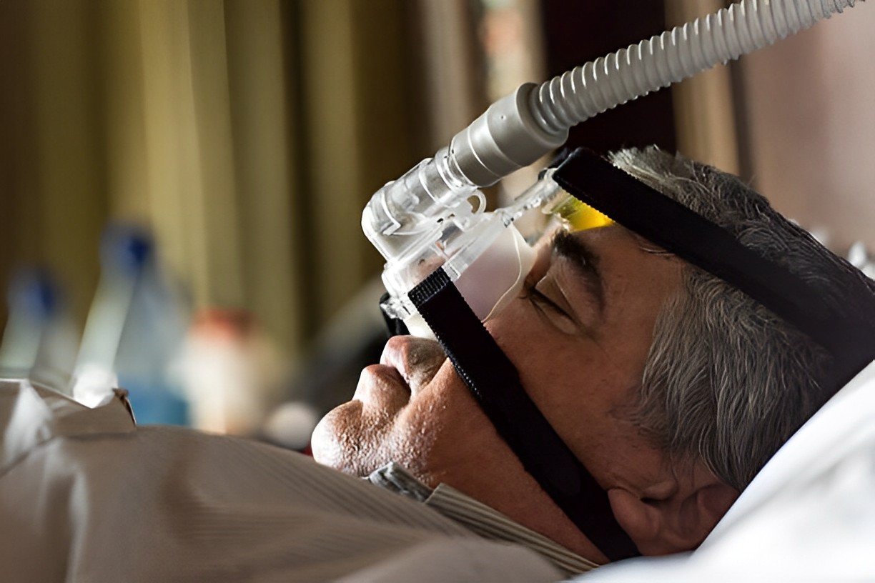 A photo of a man using a mask for apnea sleep disorder treatment
