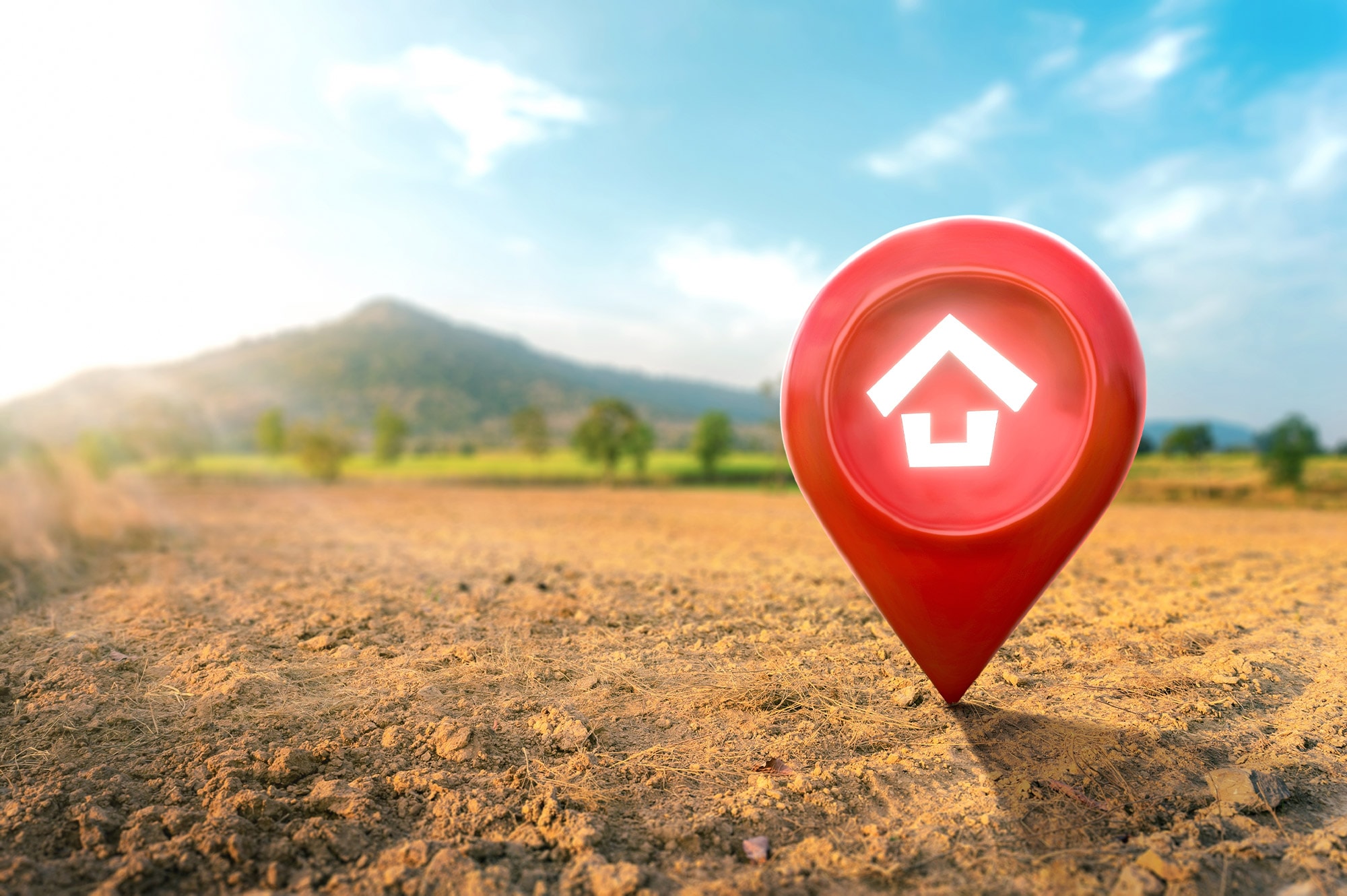 A red home-shaped location pin marks land in a rural setting—representing land selection for buyers using Land Loans in Australia