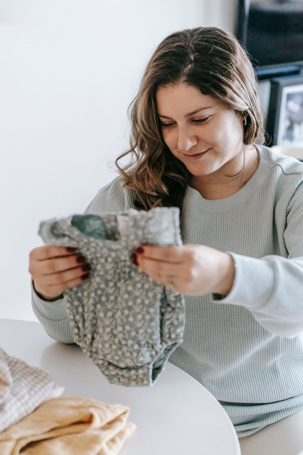 Mom holding baby clothes