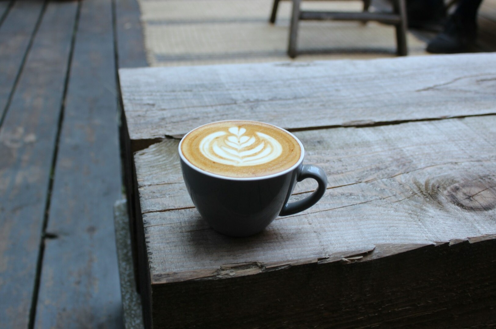 A coffee cup placed on a wooden table, highlighting Singapore's rich coffee culture.