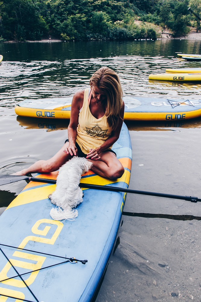 woman with her dog on a paddle board