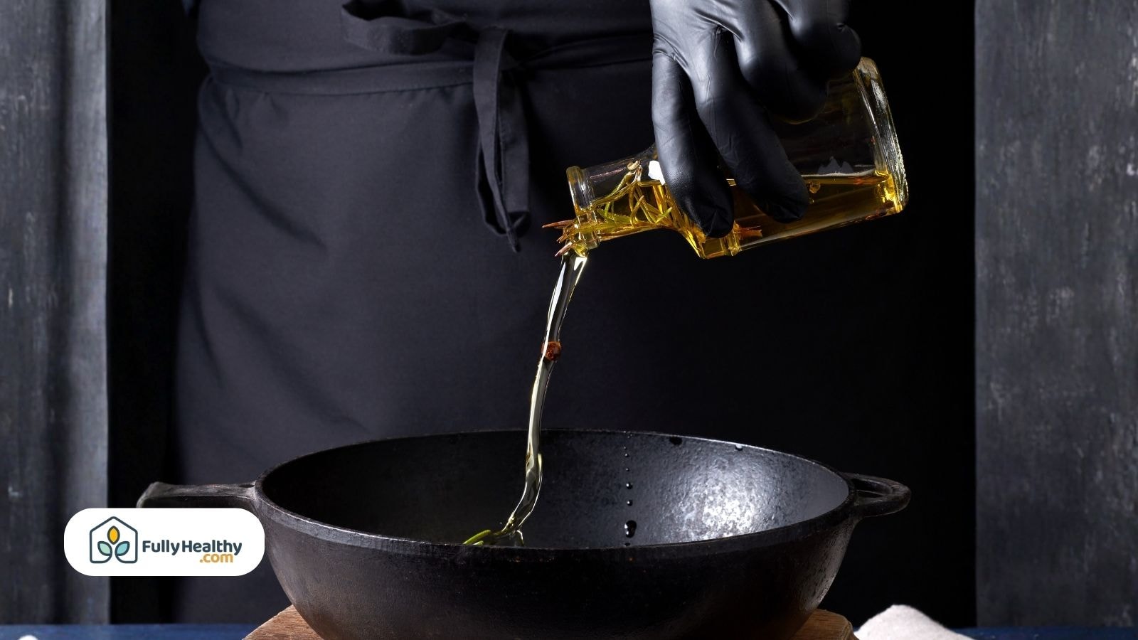 Person pouring olive oil into a black cast iron skillet