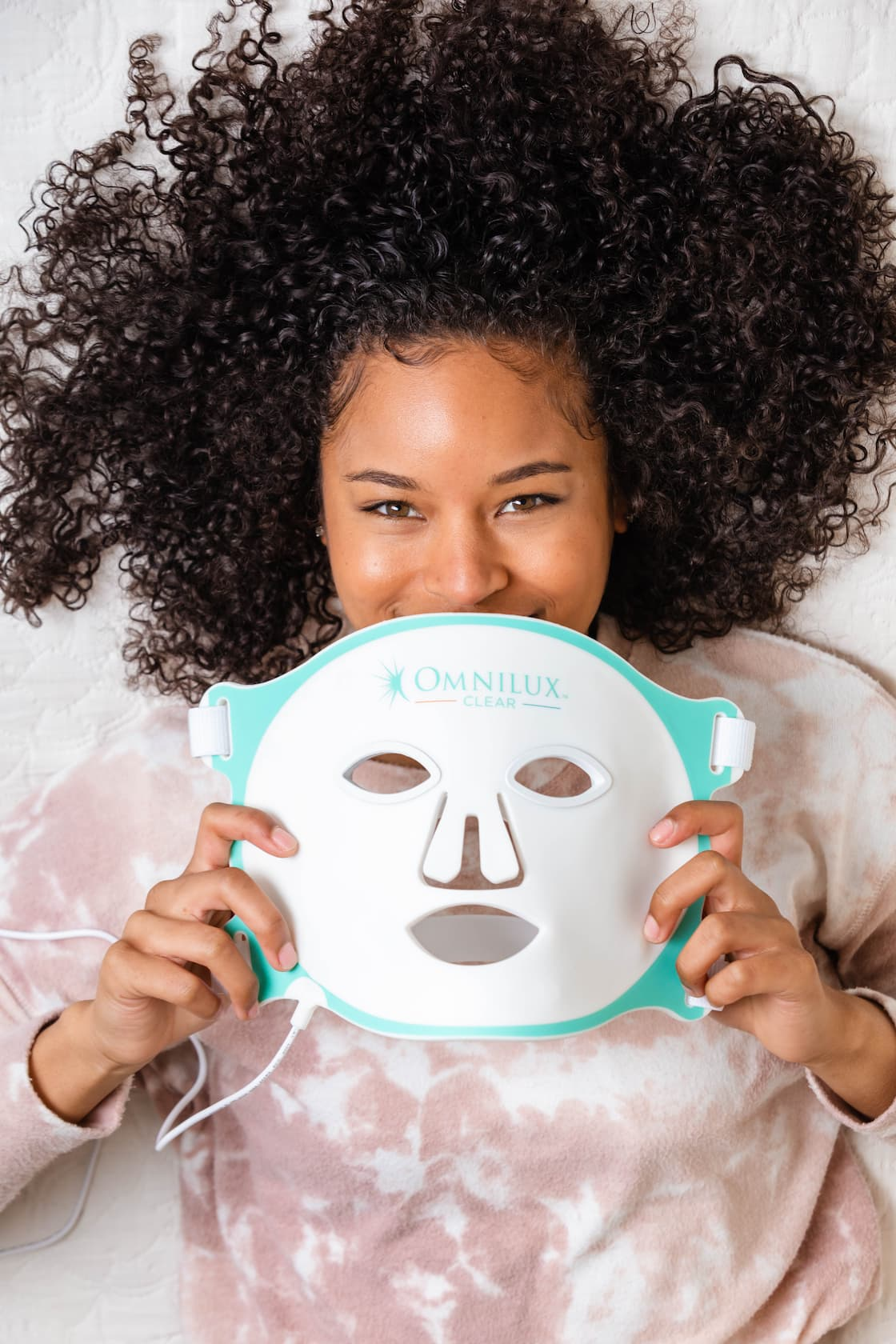 A woman using Omnilux Contour Face light therapy to maximize her experience