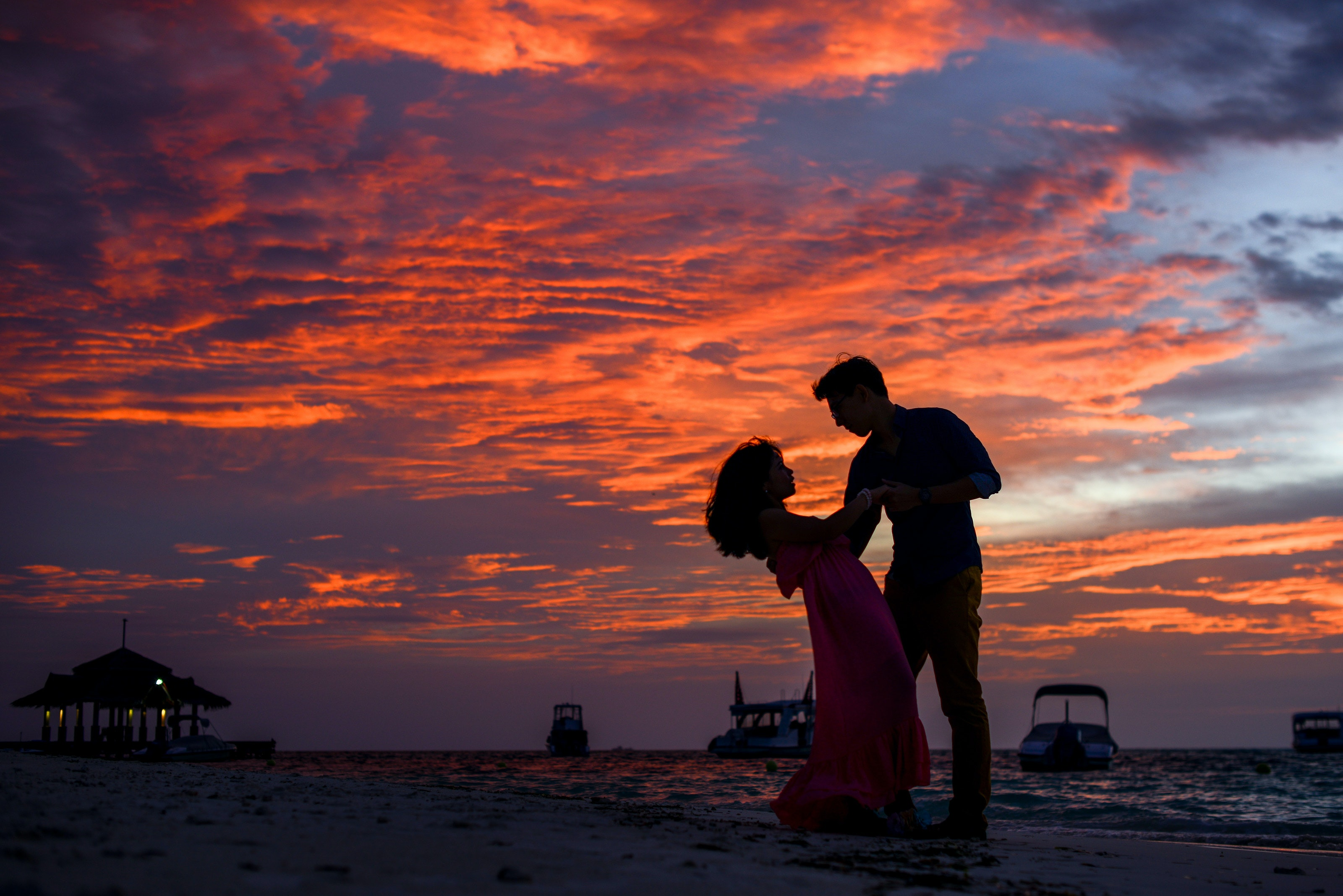 amantes apreciando o pôr do sol na praia