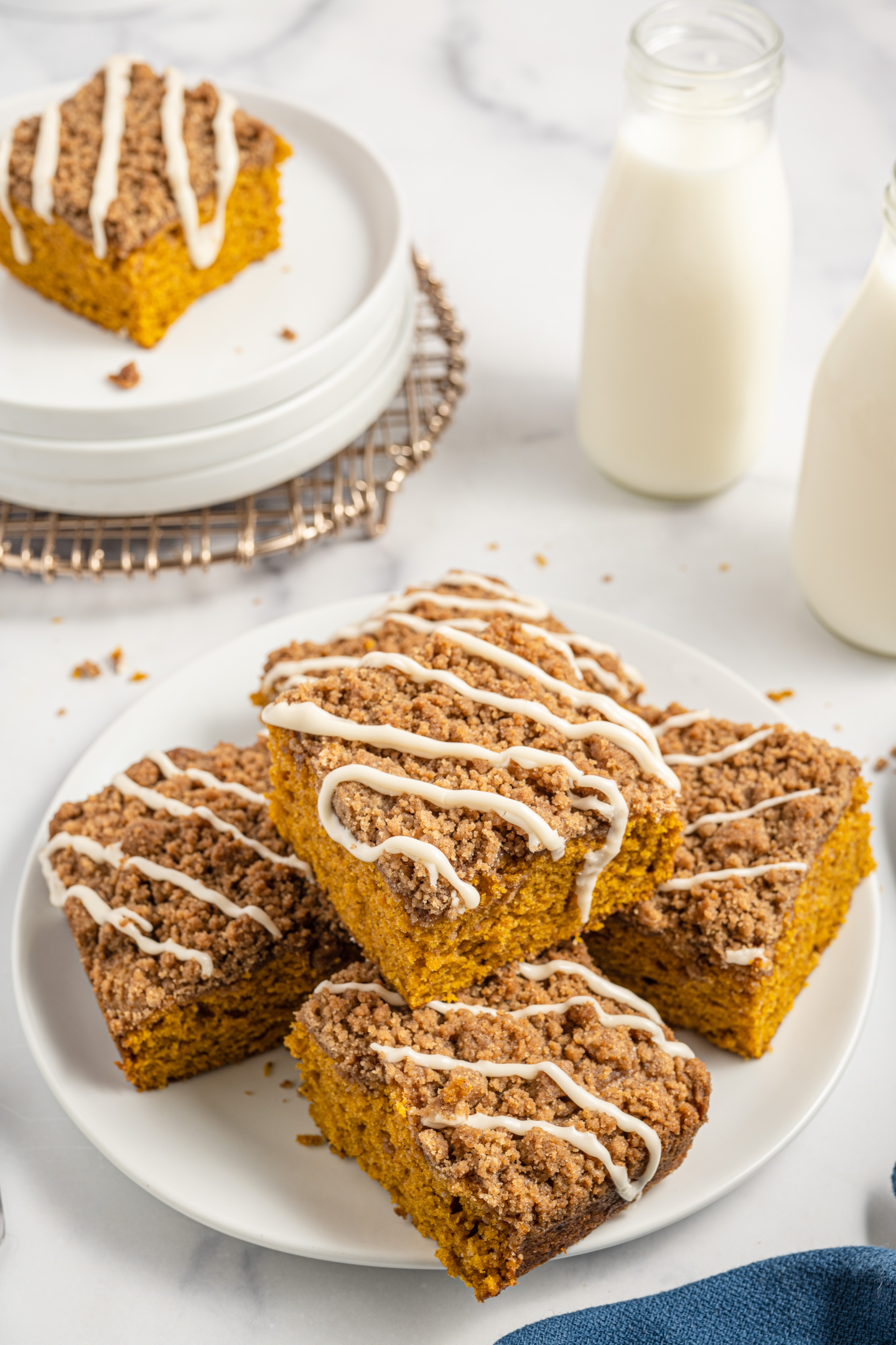 squares of pupmkin coffee cake stacked on a plate