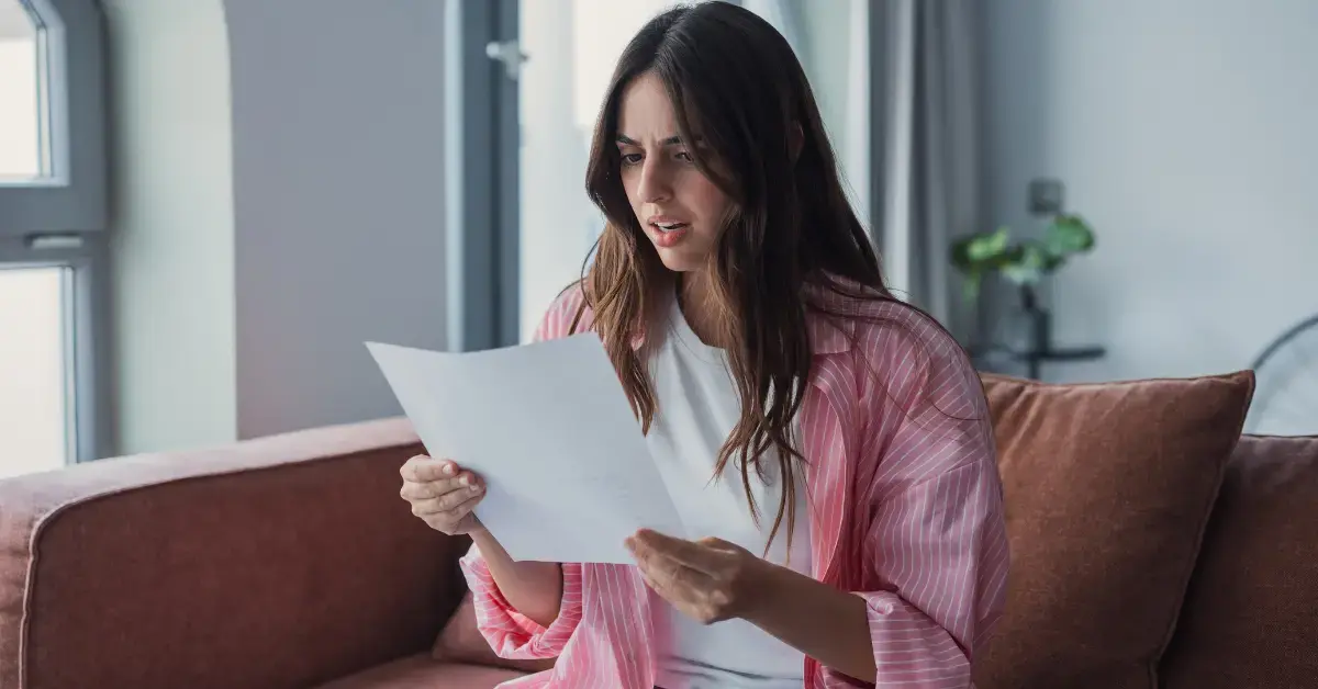 Woman reading a CP504 notice letter from the IRS at her home office.