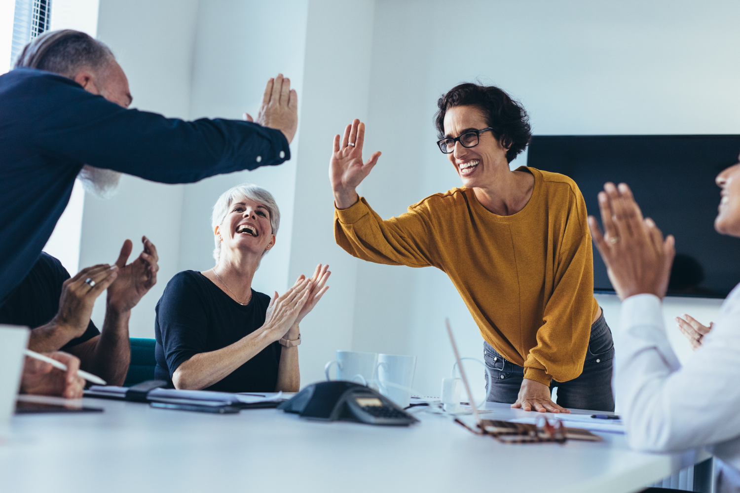  A growing team of diverse professionals shown celebrating due to onboarding success.