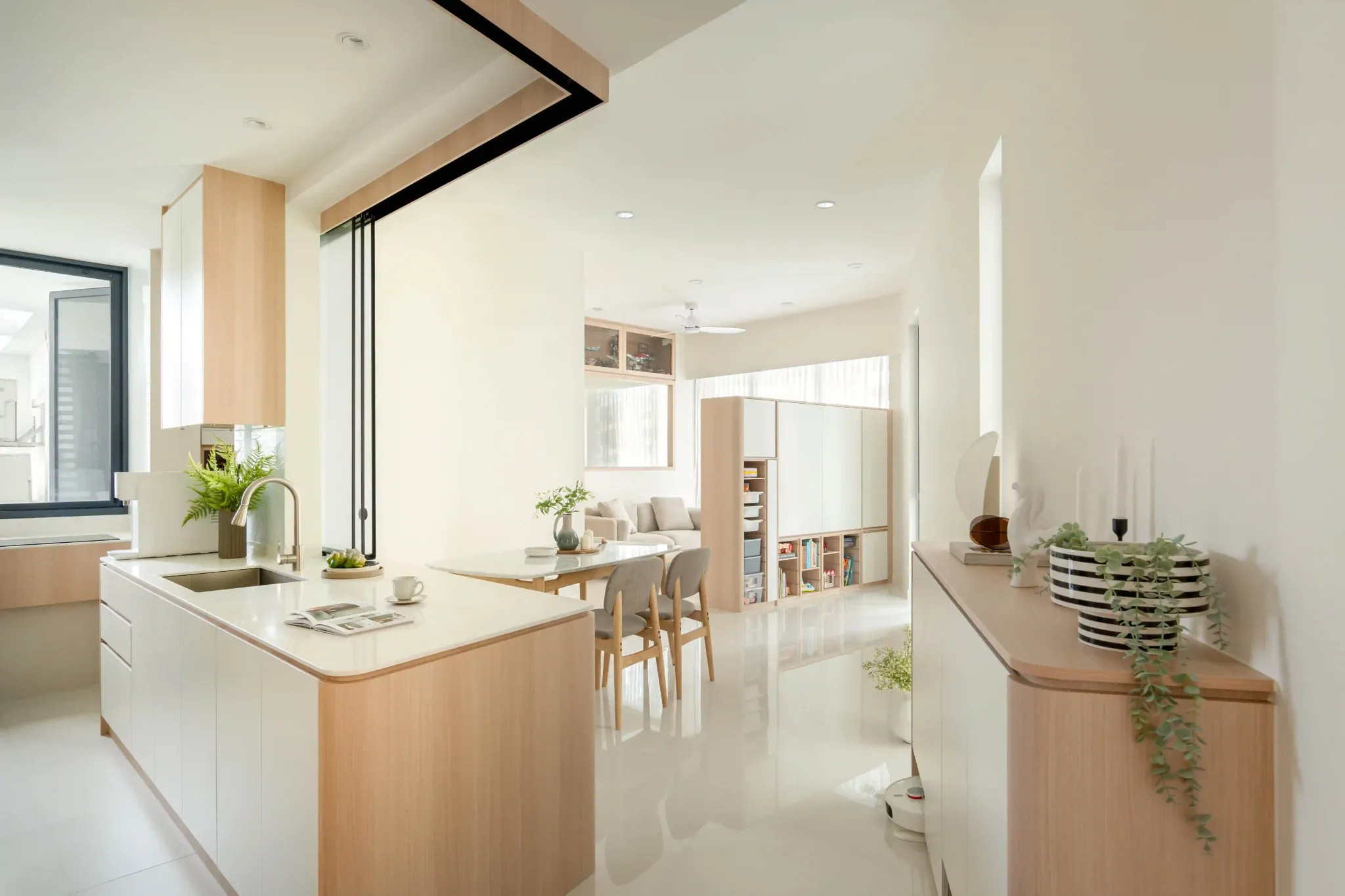 Open-plan 4 room HDB layout linking kitchen, dining and living room with light wood cabinetry and rounded corners.