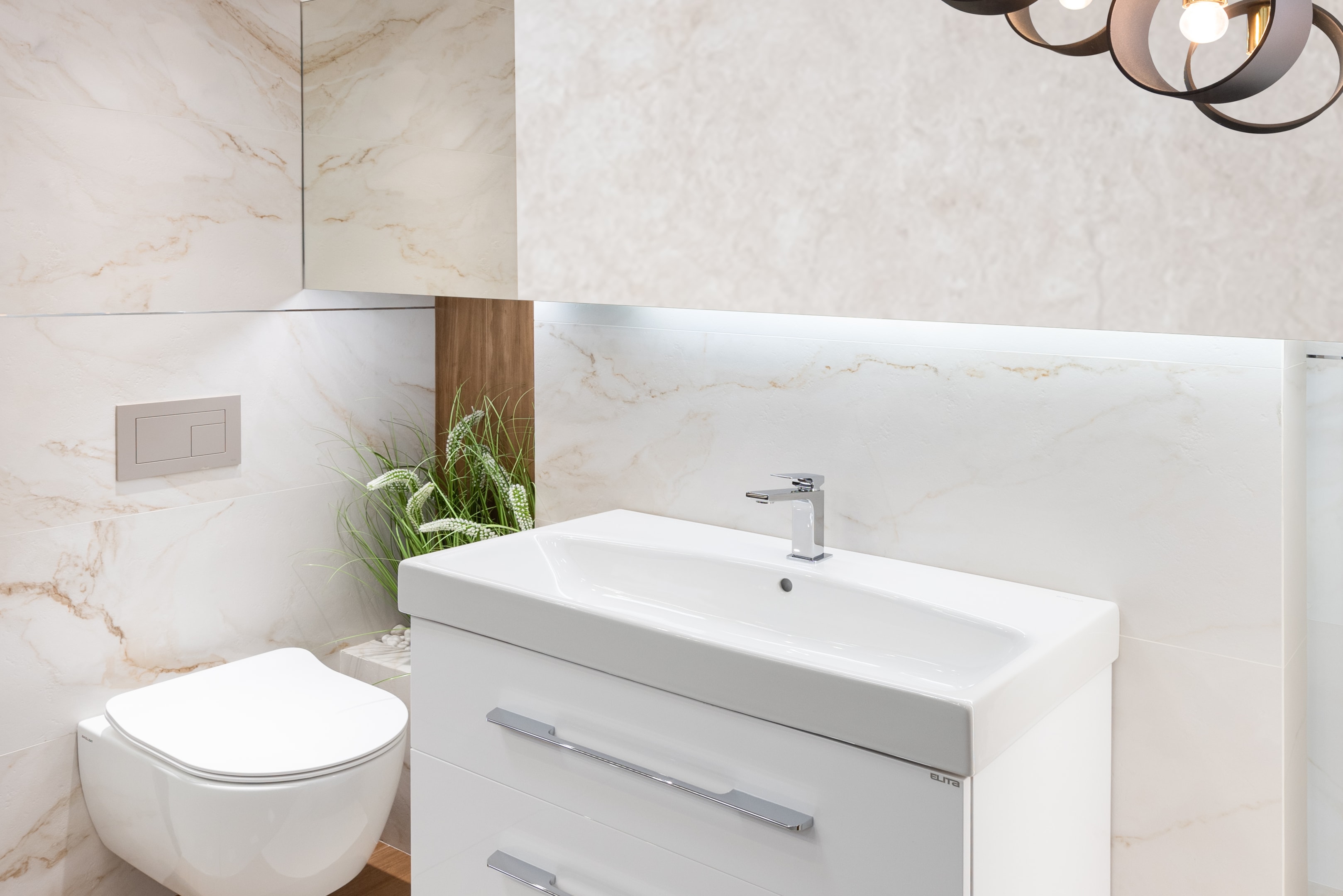 Nowoczesna łazienka w jasnych kolorach z marmurowymi płytkami i białą armaturą