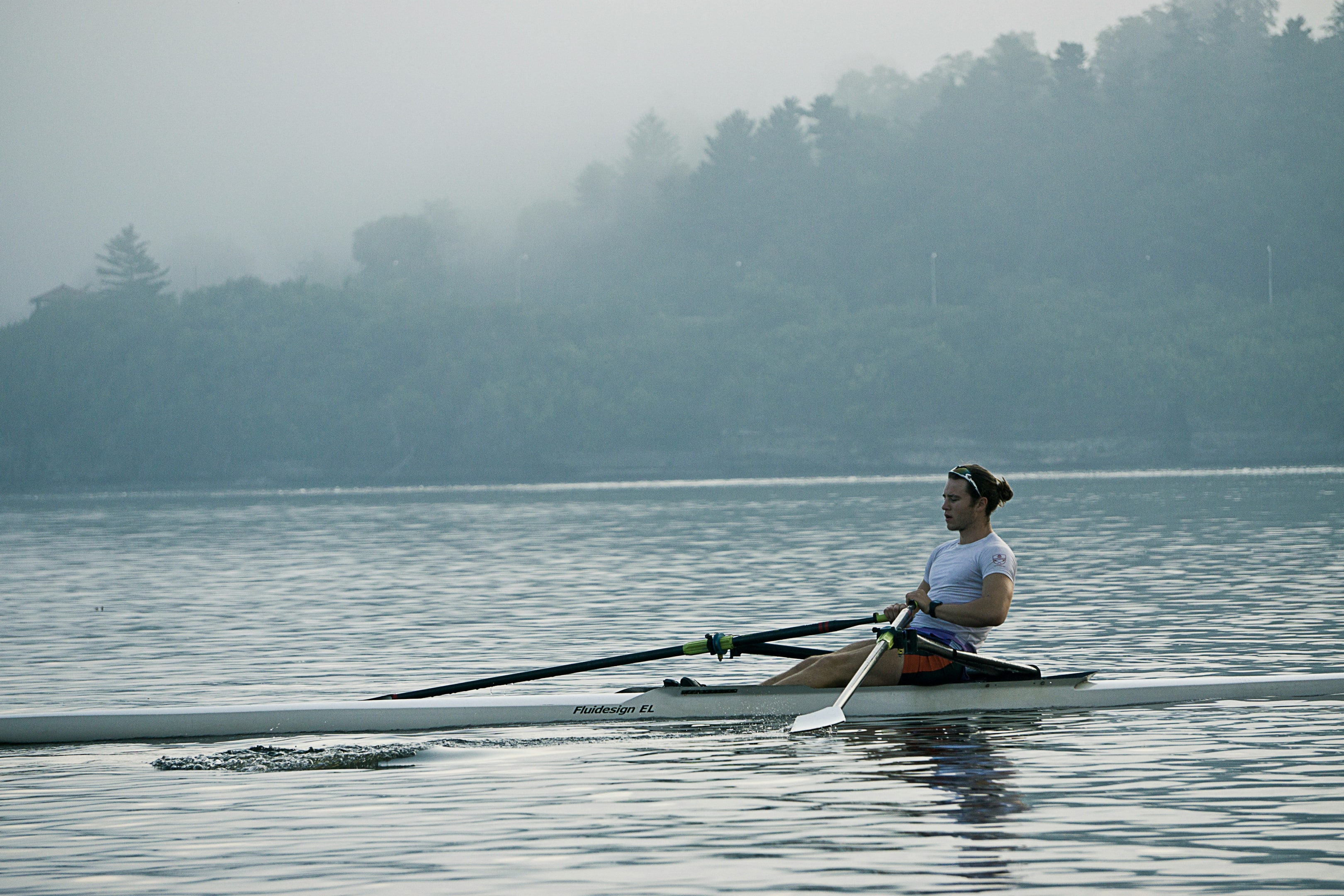 Man rowing on a calm, misty lake