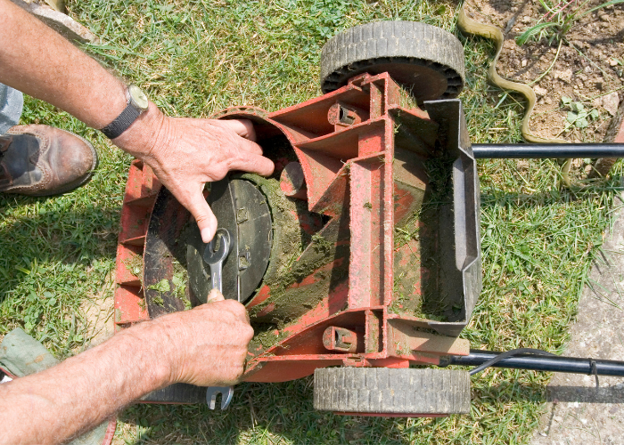 A person properly disposing of lawn mower components