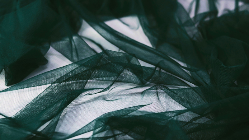 A close up view of a dark green organza fabric