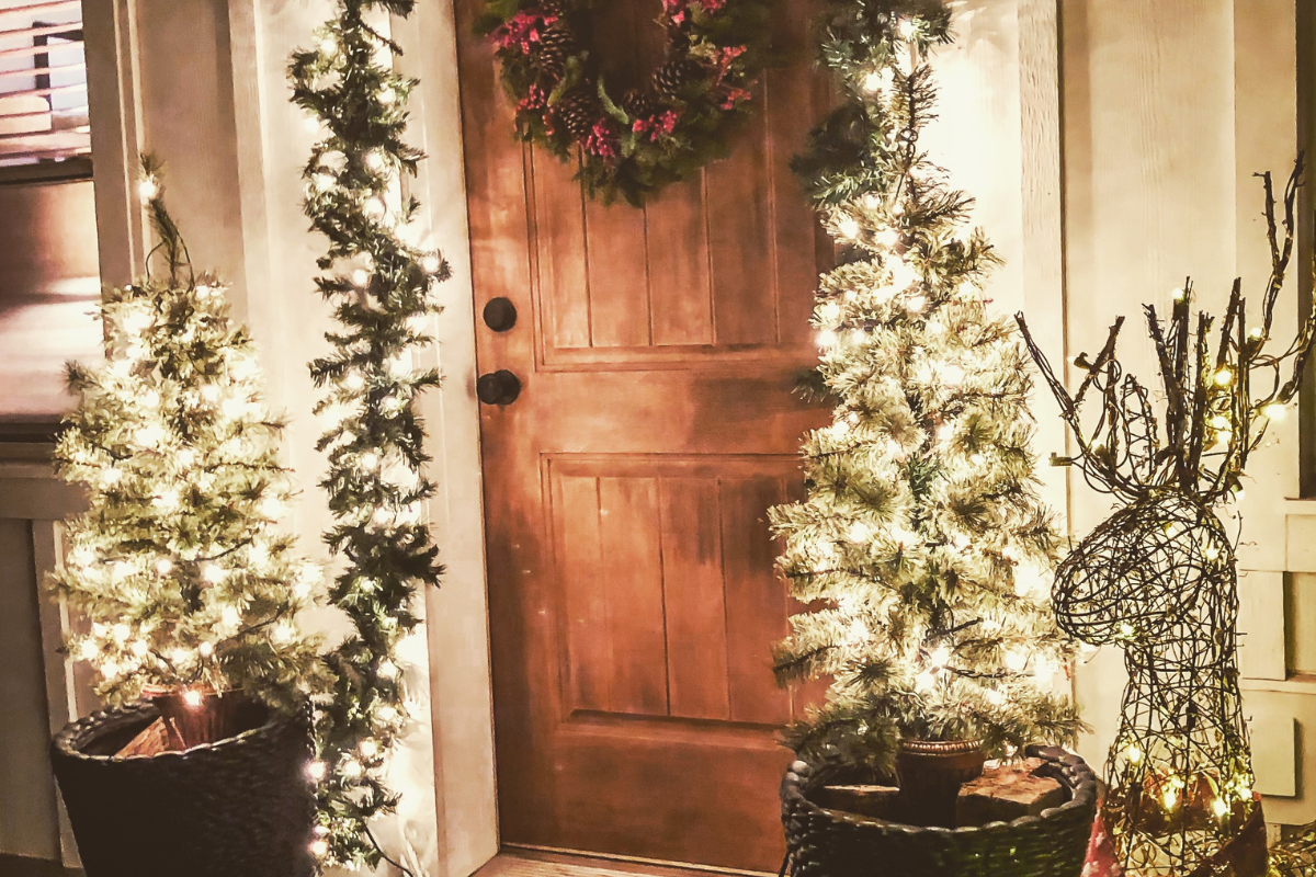 Festive porch planters filled with winter greens and decorations.