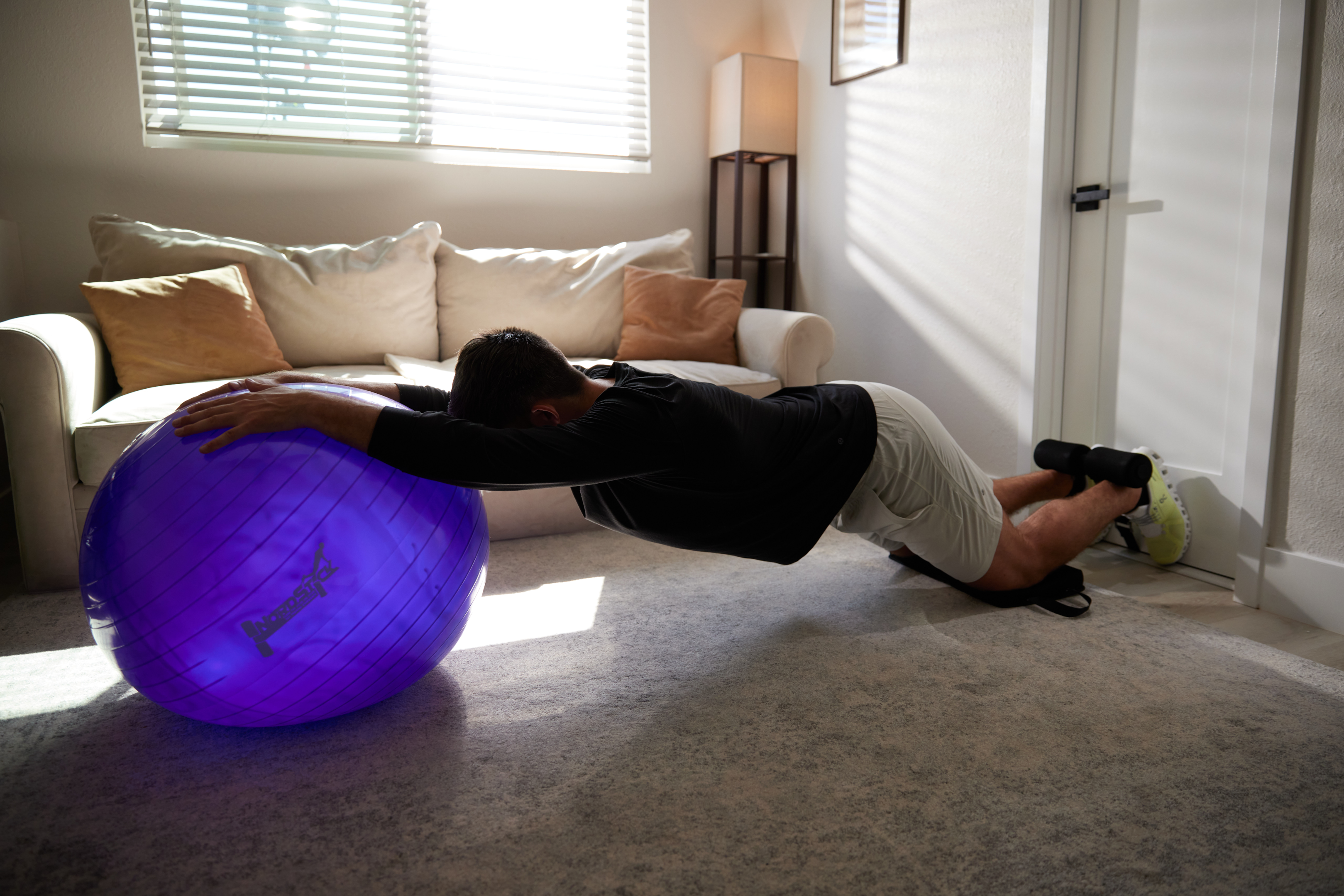 Performing a nordic hamstring curl with a yoga ball.