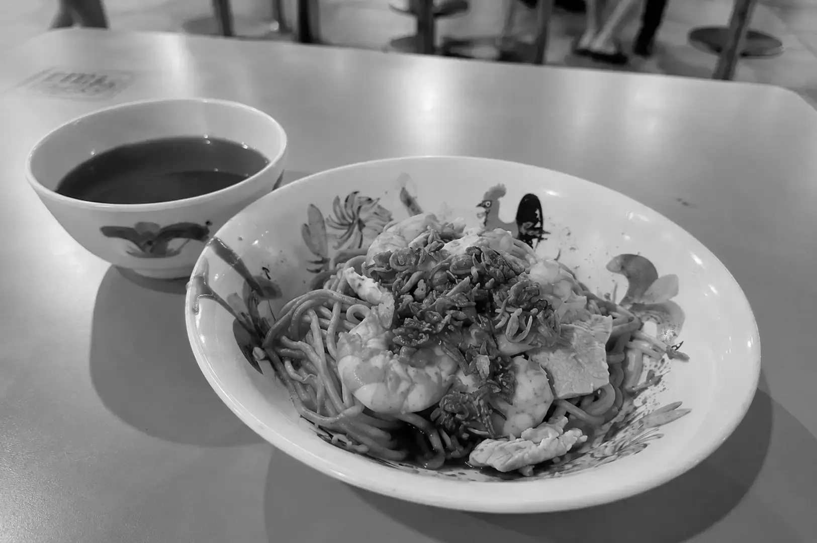Dry prawn noodles with soup on the side at a hawker centre.
