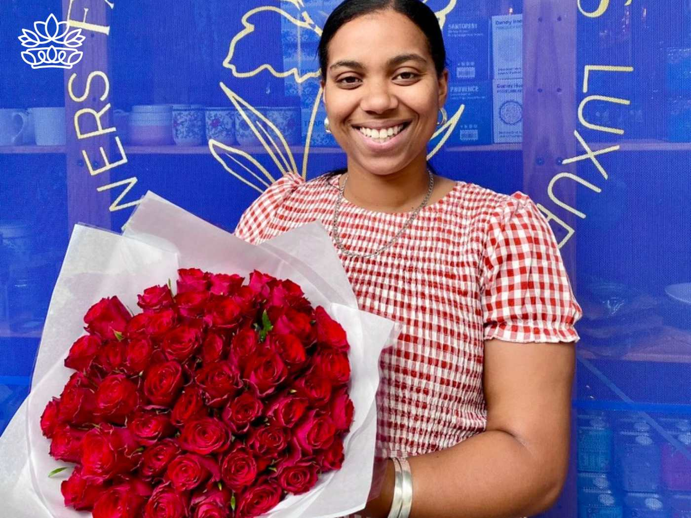 Smiling woman holding a beautiful and affordable bunch of red blooms for all occasions, from the Flower Bouquets Collection at Fabulous Flowers and Gifts, delivered with heart and soul. Shop online.