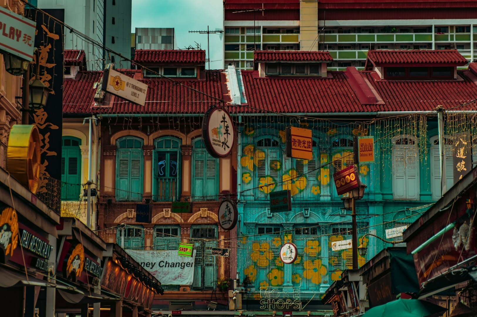 Colorful buildings line a bustling street in Chinatown, with pedestrians enjoying the lively atmosphere.