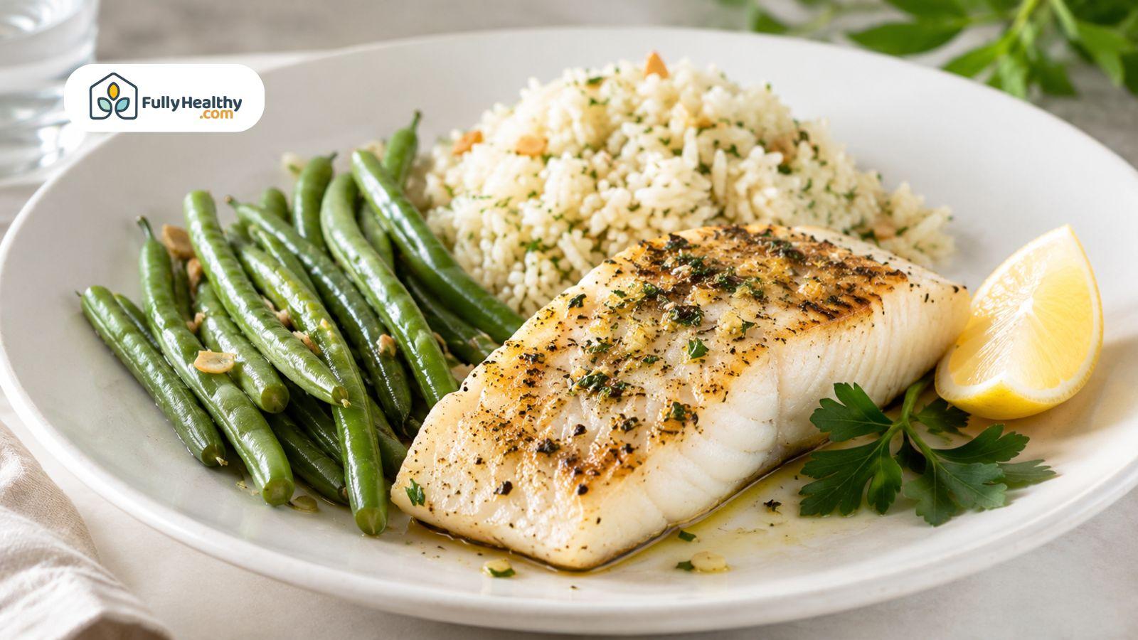 Kosher baked white fish served with green beans, couscous, and fresh lemon.