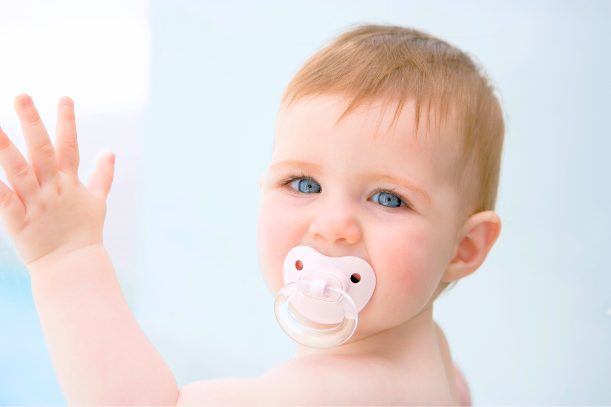 Baby with binkie and pacifier in mouth