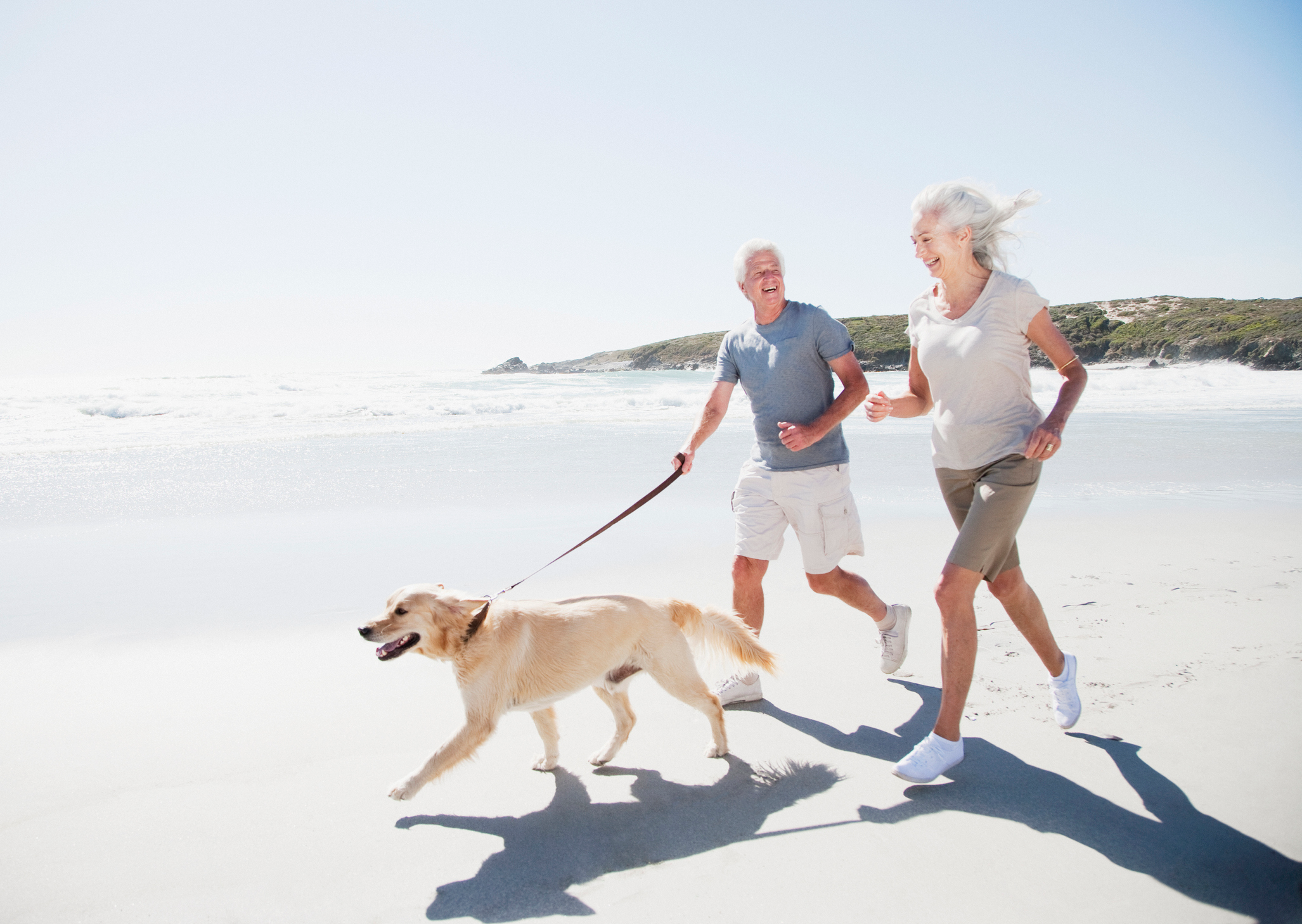 Retired couple running on the beach