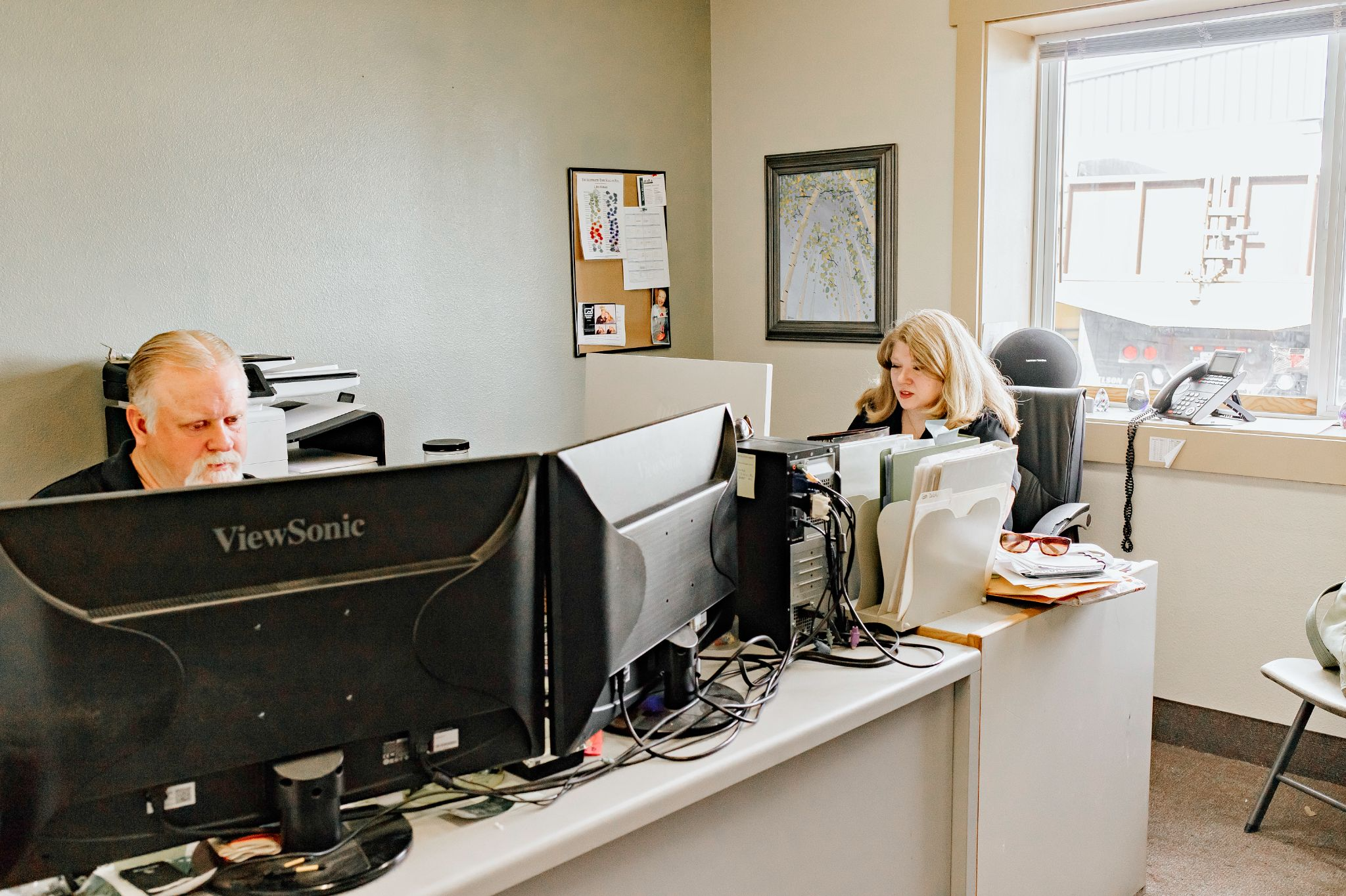 Stacy and Greg Connor, Founders of Equipment Experts, Inc. at two desks