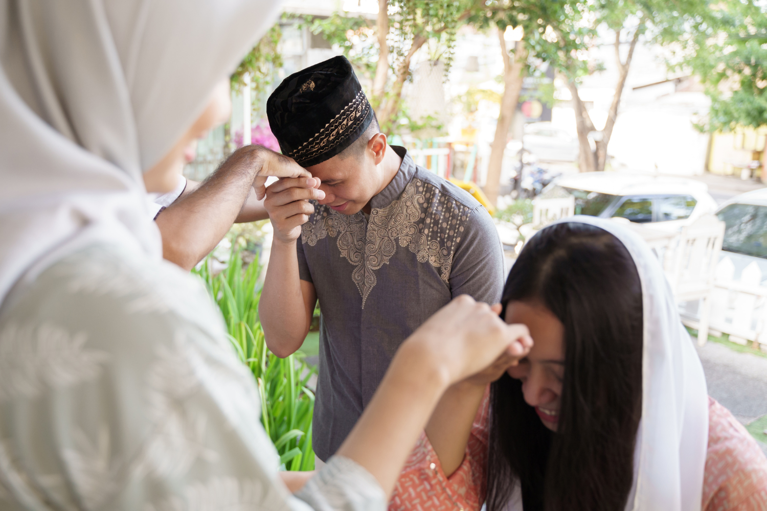 A Filipino family showing respect to elders using "mano po" in a traditional home setting.