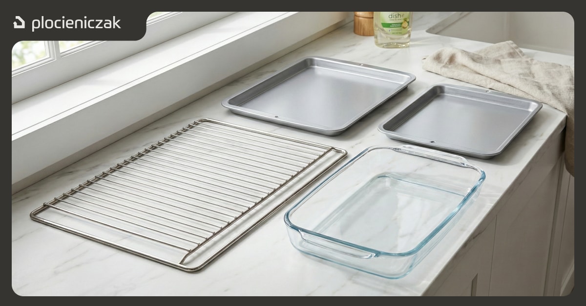Wyjęte z piekarnika ruszty, blachy i naczynie żaroodporne przygotowane do mycia