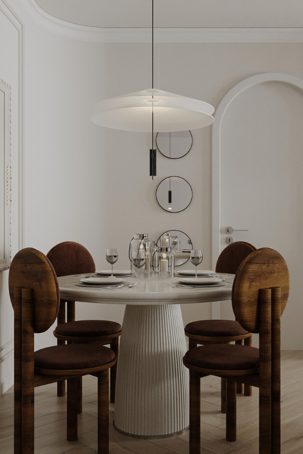 a round table with a fluted base in a dining room surrounded by circular wooden chairs