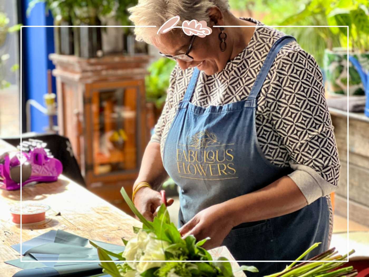 Florist in an apron working on a flower arrangement by Fabulous Flowers and Gifts