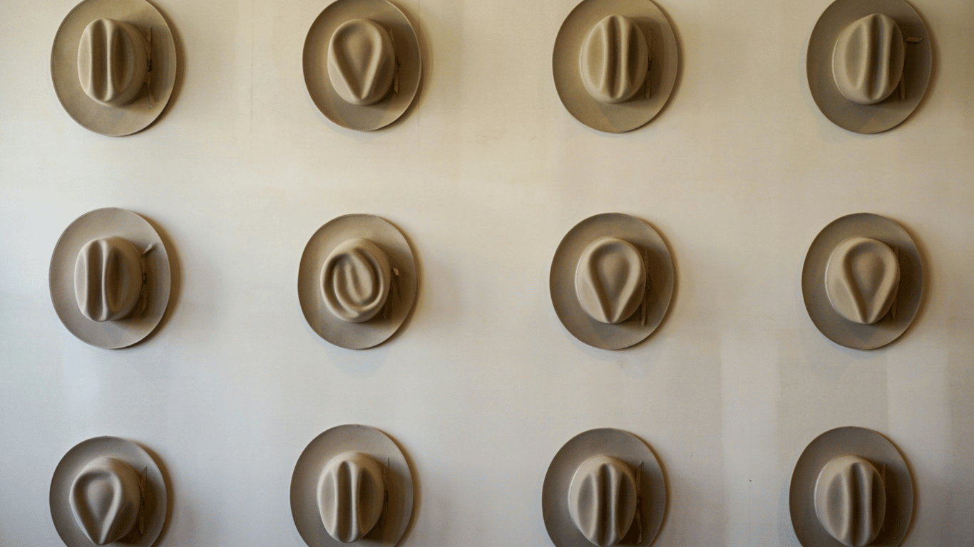 Variety of cowboy hats displayed on wall