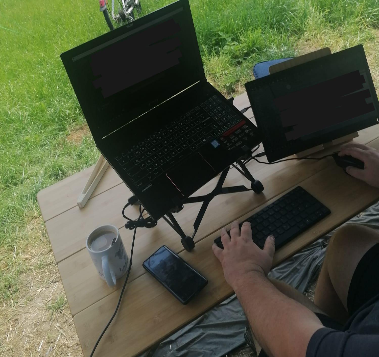 Remote Work Spanien vorm Wohnmobil, Tisch mit Technikequipment