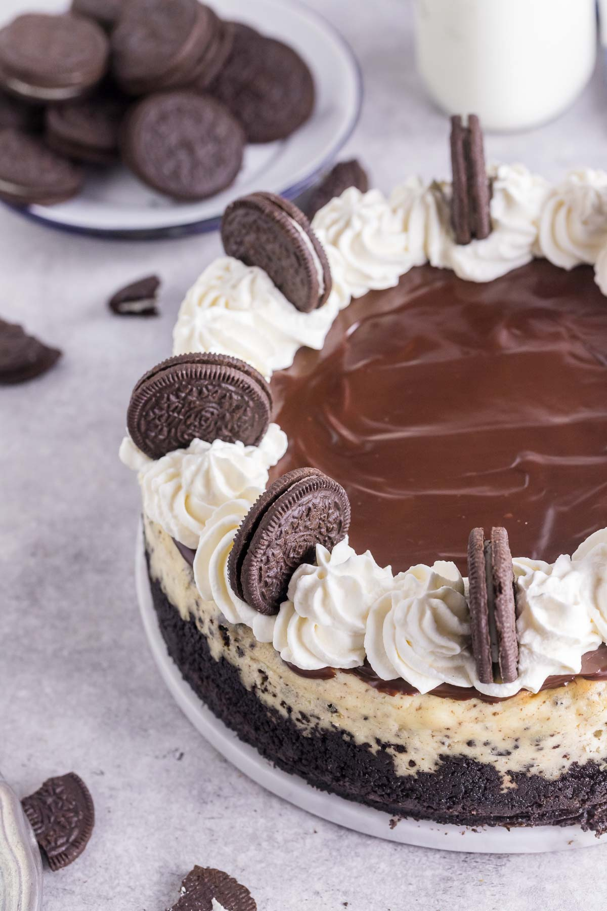 whole Oreo cheesecake topped with whipped cream and ganache
