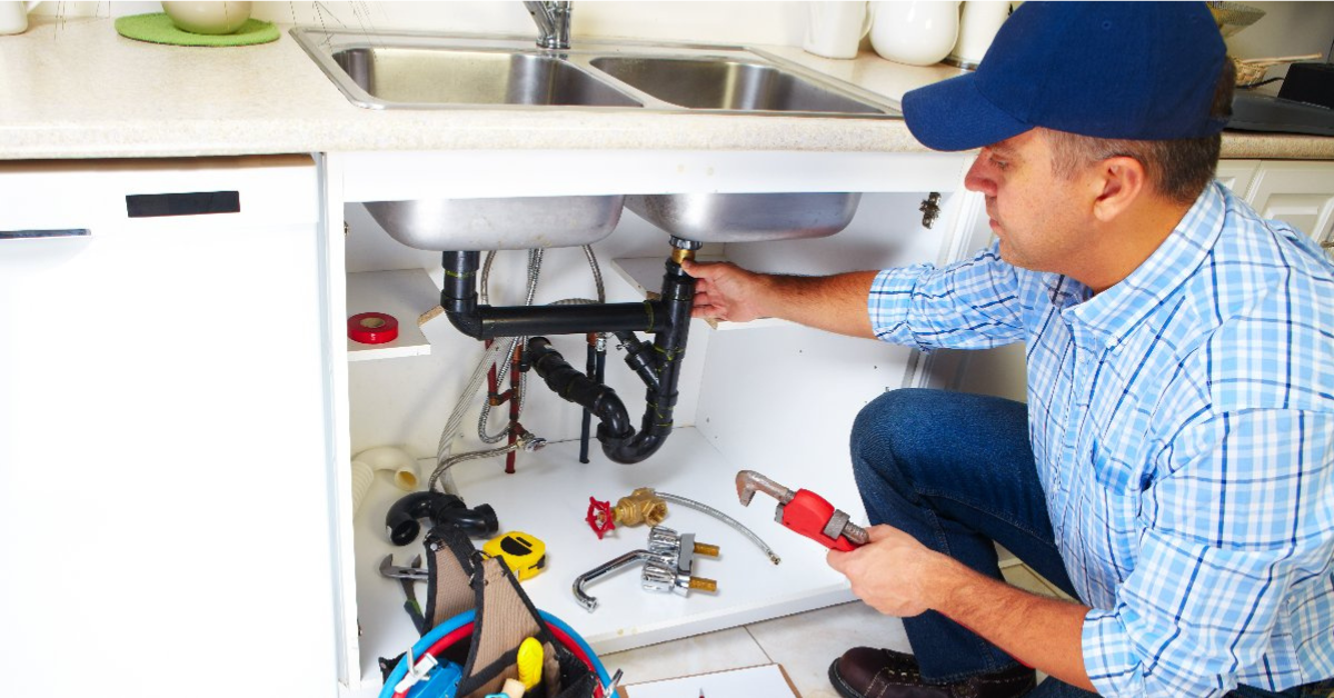 Is public utilities a good career path? Plumber working under the sink on fixing a water leak