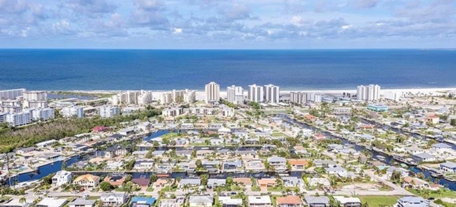 A family is enjoying a peaceful waterfront dock area, surrounded by boats and serene canal views, embodying the coastal charm of Fort Myers Beach. This tranquil retreat offers a perfect setting for relaxation and leisure, ideal for creating lasting memories with loved ones.