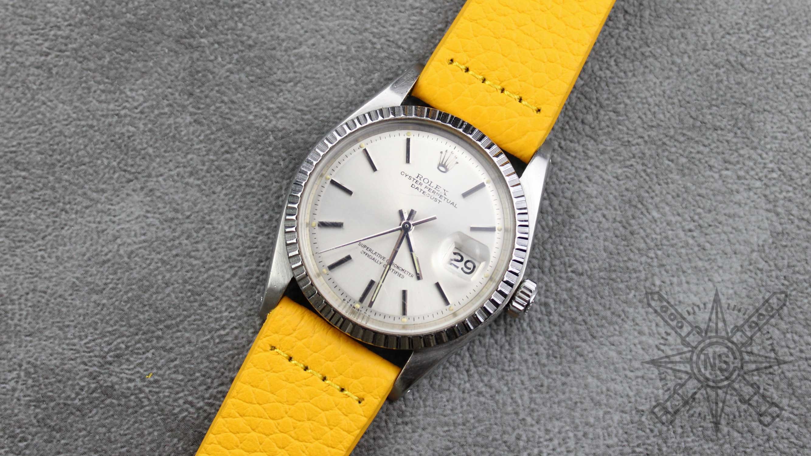 A close-up view of a yellow leather watch band displayed elegantly.