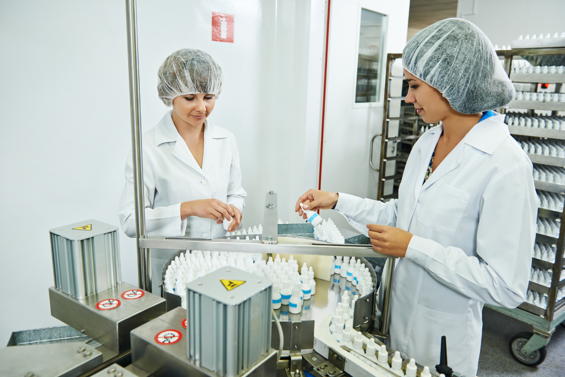Supplement manufacturing team inspecting bottles on a private label production line