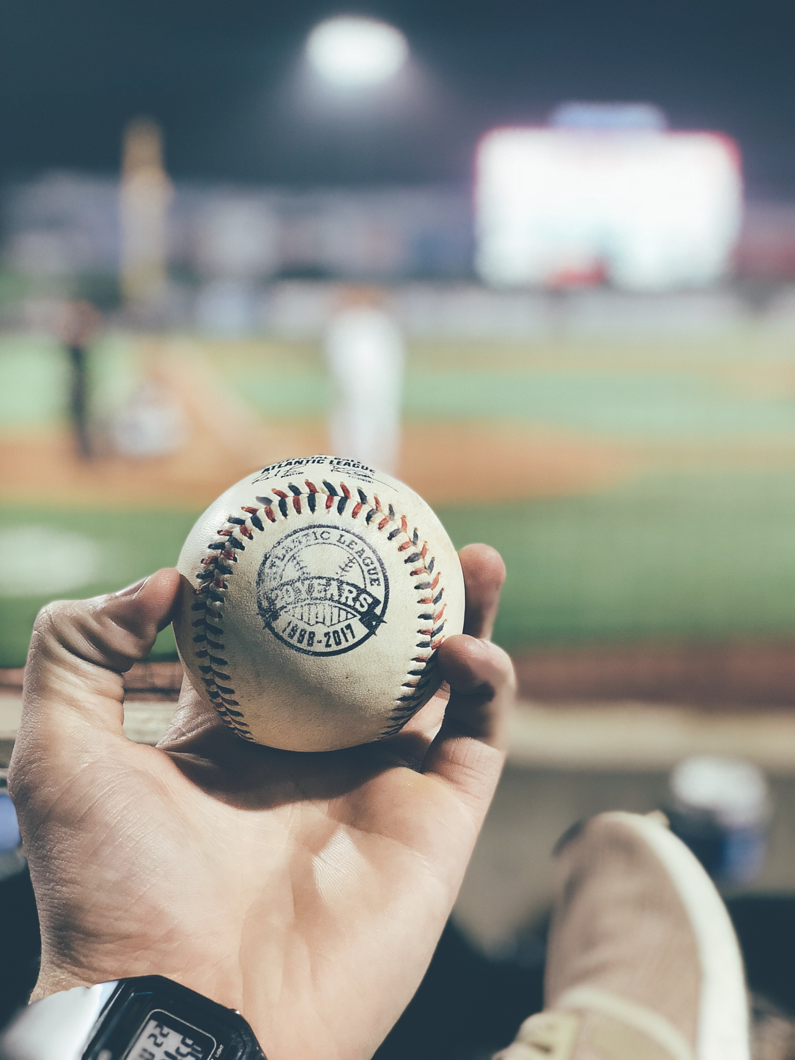 A fan catching a foul ball at an Minor League game