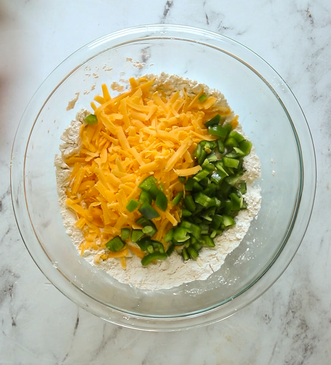 cheddar cheese and jalapenos diced into bowl