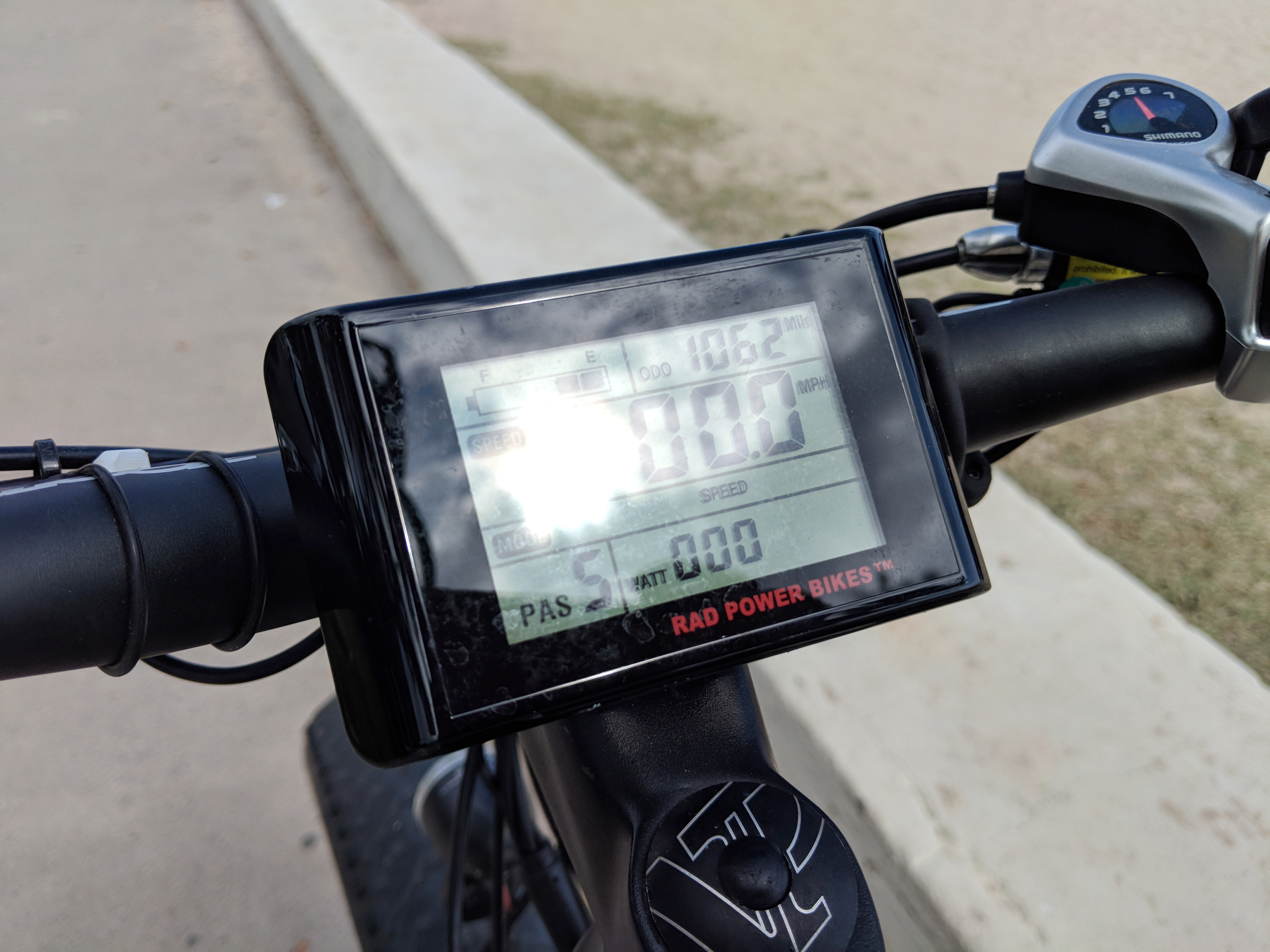A person riding an electric bike with an LCD display and pedal assistance