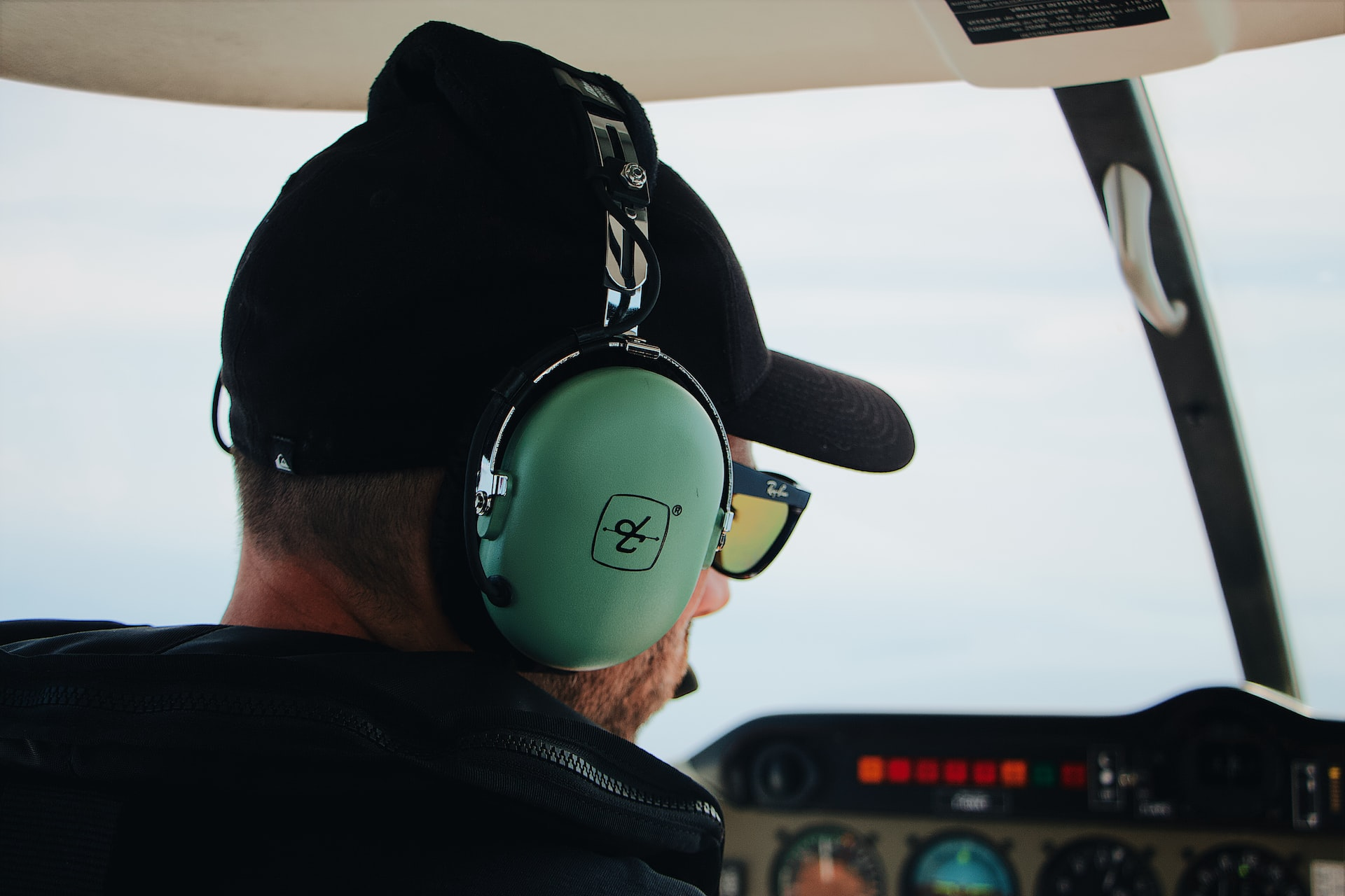 A private pilot in his aircraft wearing headphones and communicating with ATC.