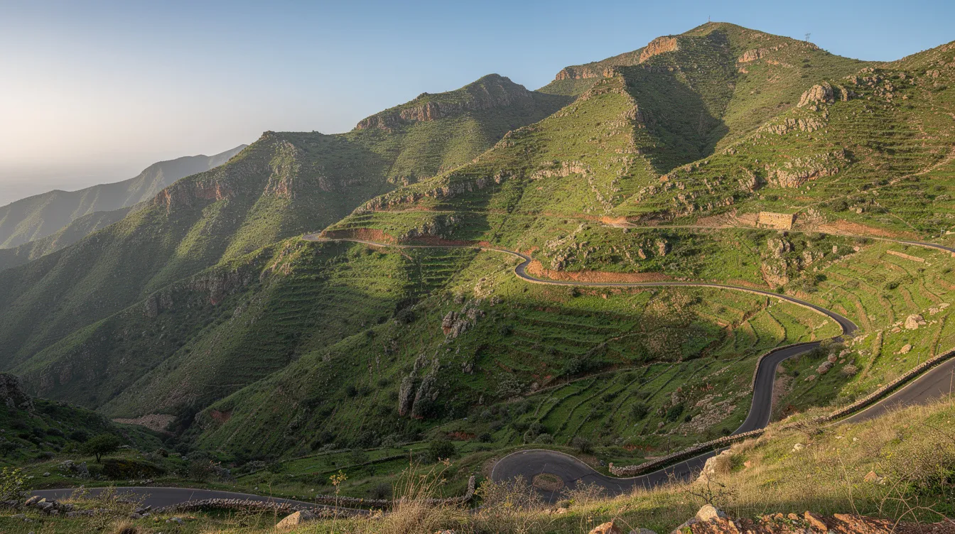 Green Rif mountains with a narrow paved road running through the landscape.