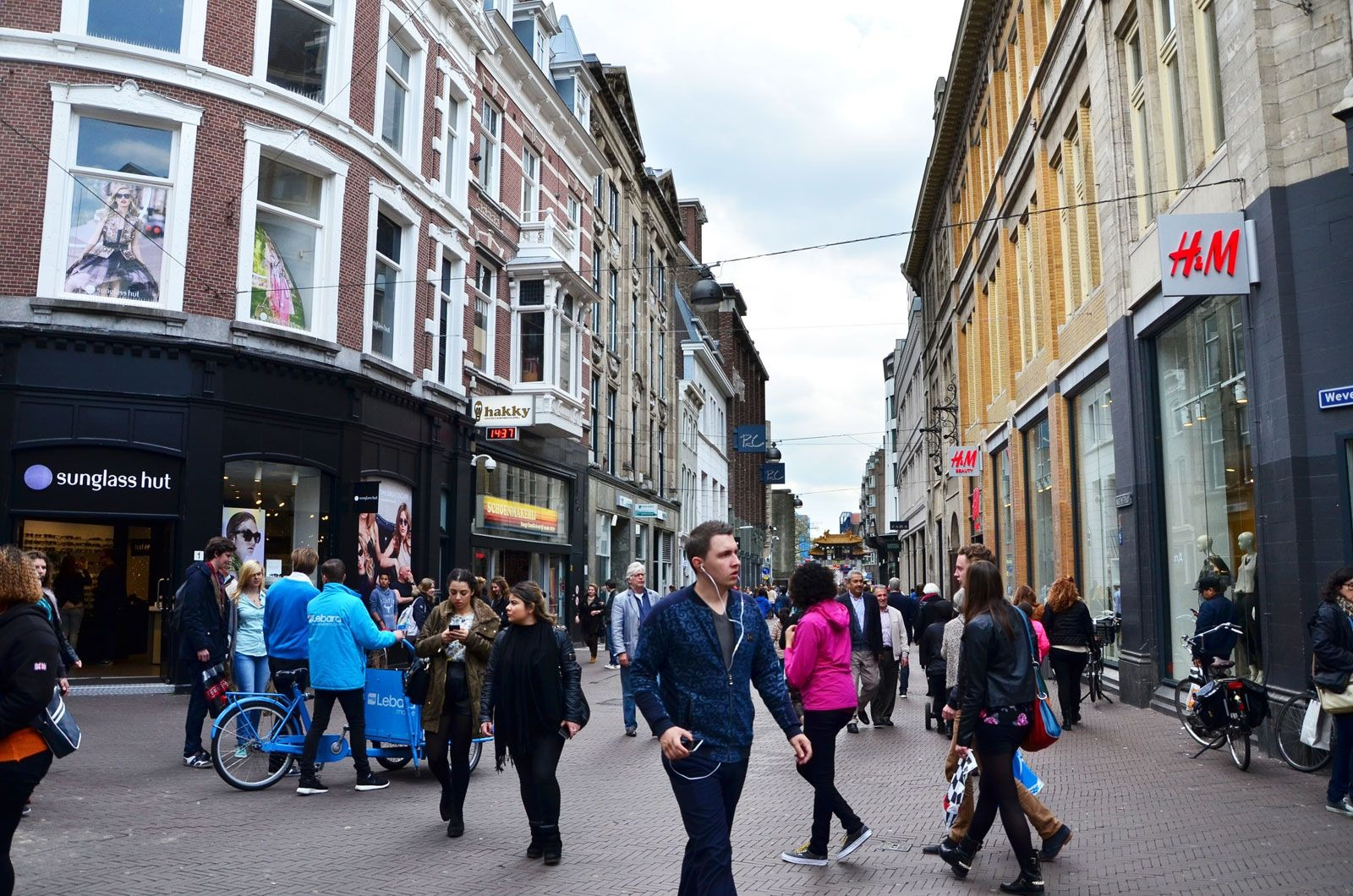 People busy walking around streets with shops