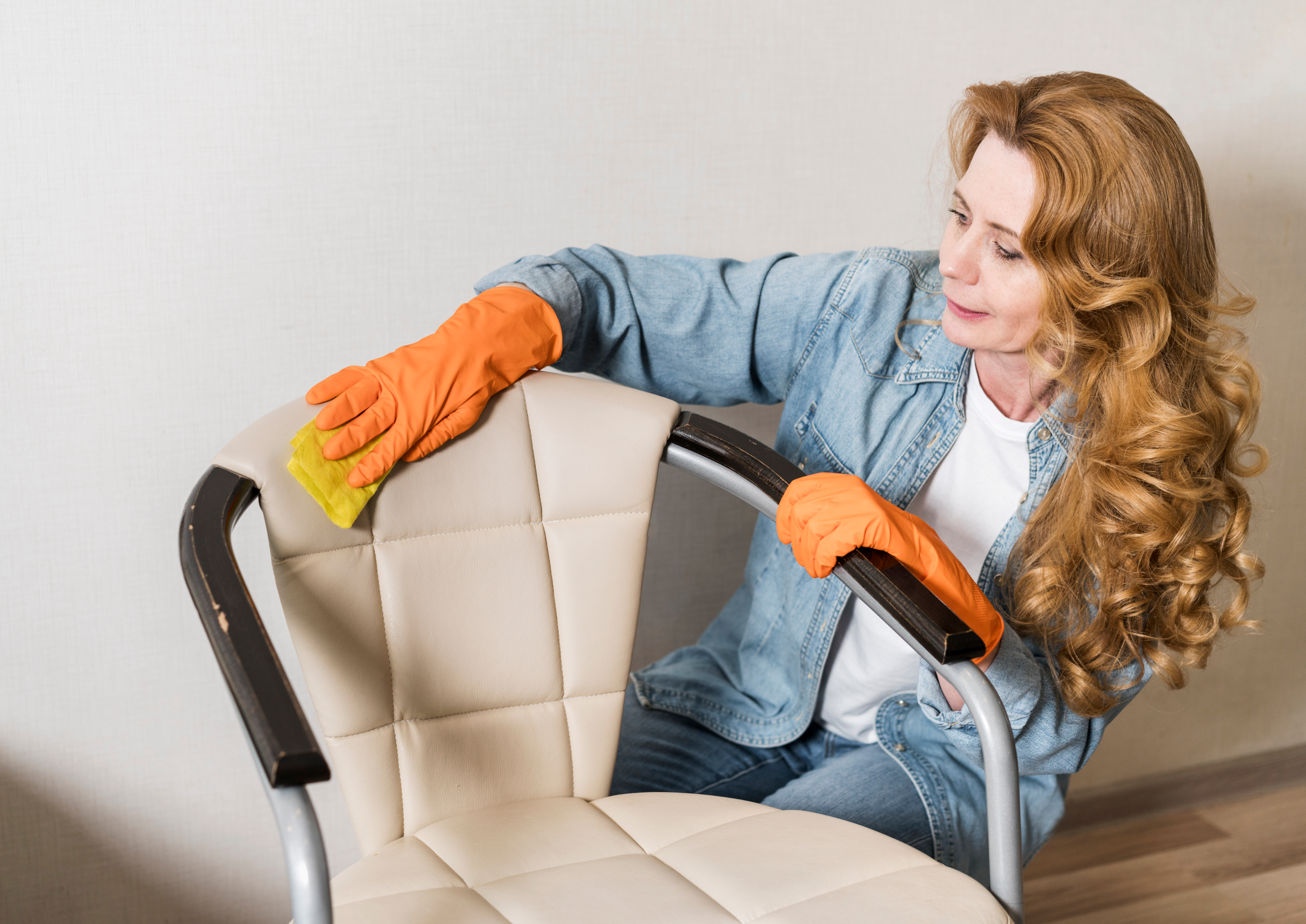 A person spot cleaning a stain on an upholstered sofa