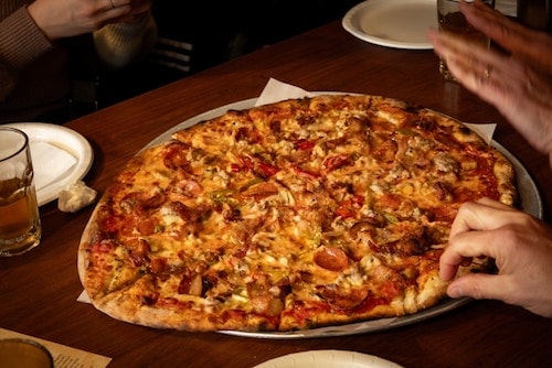Friends enjoying New Haven pizza, at Modern Apizza. You can't help yourself from feeling your mouth watering, no?