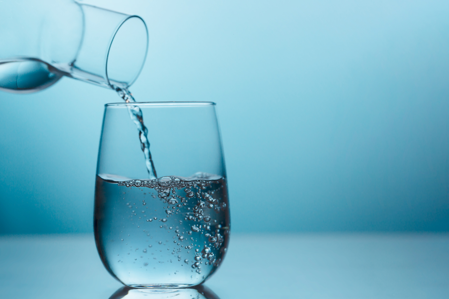 Water being poured on a clear glass.